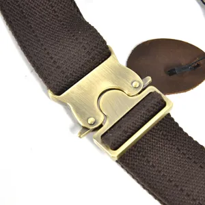 Detailed view of brown canvas strap with retro brass metal quick-release buckle for chest bag.