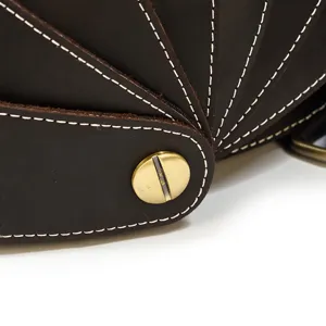 Detail view of crazy horse leather backpack, showcasing contrast white stitching and brass hardware.