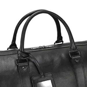 Détail de sac de voyage en cuir noir, poignée et fermeture éclair haut de gamme pour hommes.