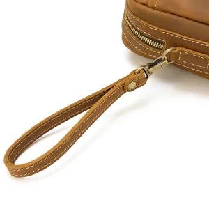 Vue détaillée de la dragonne en cuir véritable marron et de la fermeture éclair en métal.