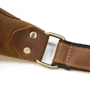 Detailed view of brown crazy horse leather bag strap, metal D-ring and rivet hardware.