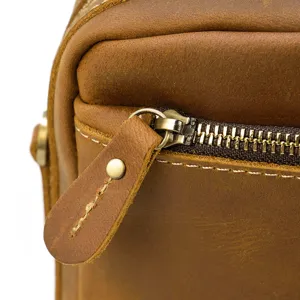 Gros plan sur les details de sac homme en cuir veritable avec fermeture eclair metallique.