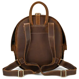 Backpack detail view showing sturdy leather straps, fine stitching, and durable metal hardware.