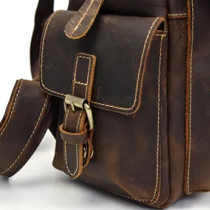 Close-up detail of retro crazy horse leather men backpack with metal buckle and stitching.