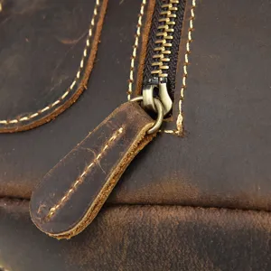Close-up detail of vintage crazy horse leather backpack zipper and pull tab, durable.