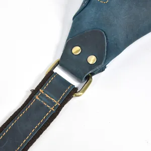 Detail view of vintage genuine crazy horse leather chest bag strap and metal hardware buckle.