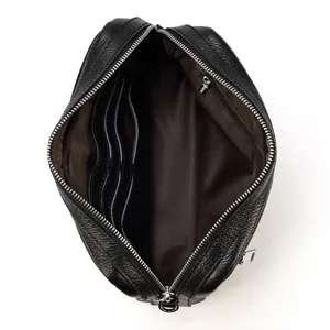 Détail intérieur de sac bandoulière en cuir avec fentes pour cartes et poche zippée pratique.