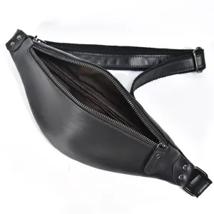 Detail view of black leather fanny pack, zipper open showing interior, adjustable strap.