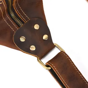 Detail shot of vintage crazy horse leather chest bag strap connection with metal hardware.