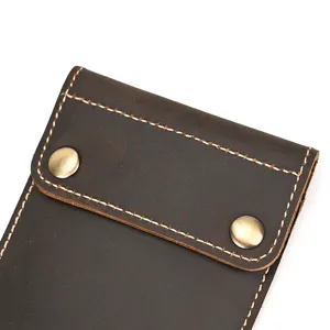 Close-up detail of vintage crazy horse leather watch pouch with contrast white stitching snap.