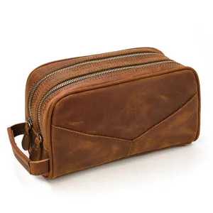 Detail view of the brown leather toiletry bag, showcasing the durable double zippers.