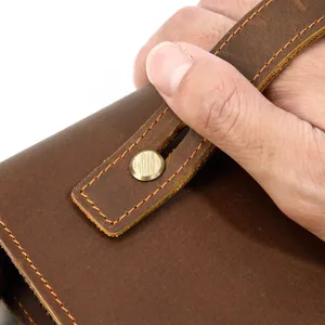 Close-up detail of premium vintage crazy horse leather wallet strap and metal snap button.