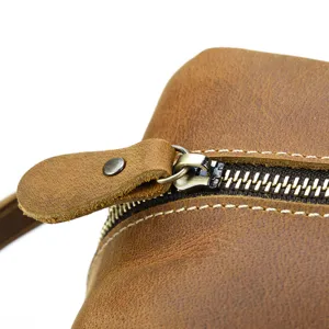 Close up of genuine leather toiletry bag zipper detail, vintage brown leather texture and metal.