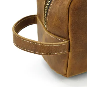 Close-up detail of vintage genuine leather toiletry bag zipper and handle craftsmanship.