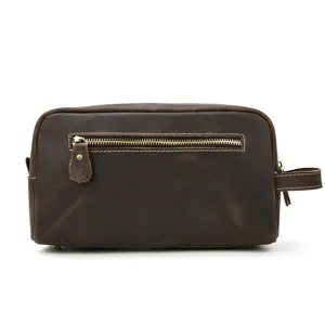 Close-up detail of vintage genuine leather toiletry bag with front zipper and side handle.