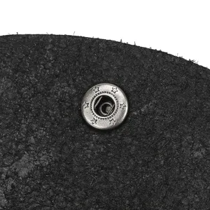 Leather coin purse detail shot, black cowhide texture with star pattern metal snap button.