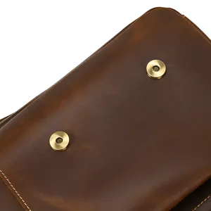 Detailed shot of vintage crazy horse leather men briefcase with brass magnetic snap and stitching.