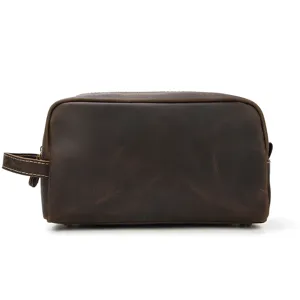 Detailed close-up view of vintage brown genuine leather toiletry bag with side handle and zipper.