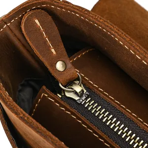 Close-up detail of vintage brown crazy horse leather men briefcase zipper and hardware.