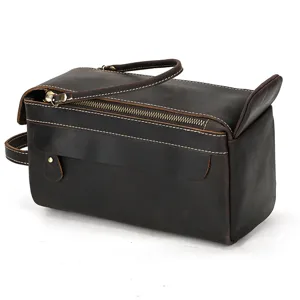 Close-up detail of vintage brown crazy horse leather toiletry bag zipper and handle design.