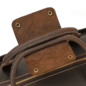 Genuine leather travel bag detail close-up, premium dark brown vintage luggage handle texture.