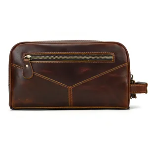 Closeup detail of vintage brown leather toiletry bag showing zipper and side handle.