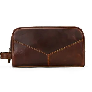 Detail of vintage brown genuine leather toiletry bag with zipper and side handle.