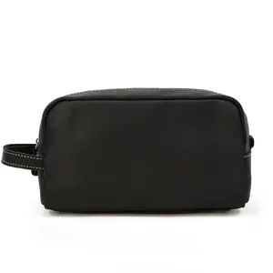 Close-up view of the black leather toiletry bag showcasing fine contrast stitching details.