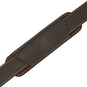 Detail view of the brown leather bag strap with durable white stitching and comfortable shoulder pad.
