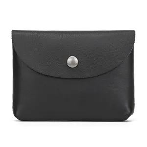 Detail close-up of the black leather coin purse showing the snap button and fine texture.