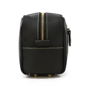 Black genuine leather toiletry bag side view showcasing zipper and metal feet details.