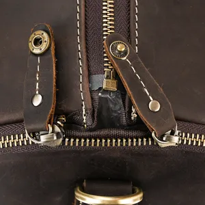 Close-up detail of vintage leather travel duffel bag with sturdy zipper and brass hardware.
