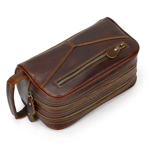 Detail view of genuine leather toiletry bag with double zippers and vintage craftsmanship.