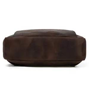 Detailed view of the bottom part of a vintage crazy horse leather backpack, dark brown cowhide.