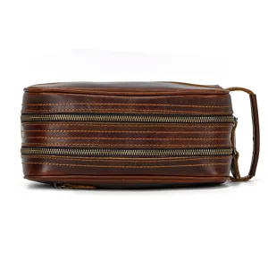 Genuine leather toiletry bag detail view, vintage brown cosmetic pouch with double zippers.