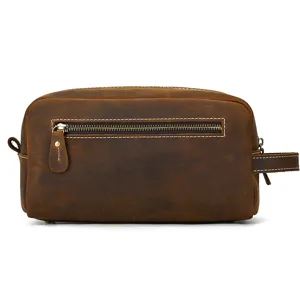 Detail view of brown leather dopp kit, featuring smooth metal zipper and durable stitching texture.