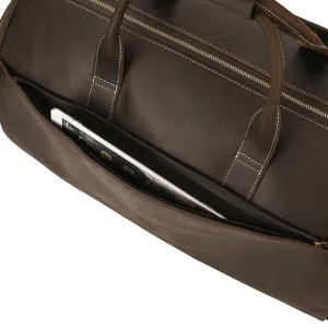 Leather vintage travel duffel bag detail showing front pocket and zipper storage capacity.