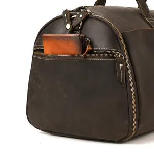 Detail shot of vintage leather travel duffel bag front zipper pocket and fine stitching craftsmanship.