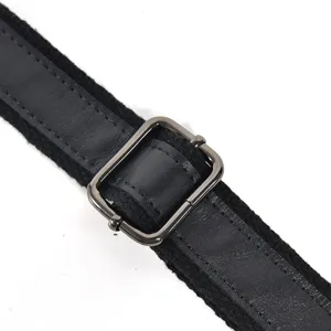 Detailed view of the black genuine leather bag strap and durable metal adjustment buckle.