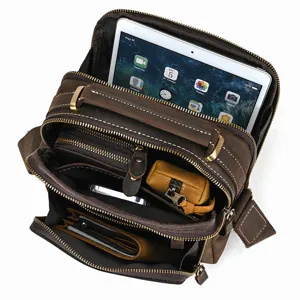 Detailed view of multi-compartment leather shoulder bag showing ample space for iPad and essentials.