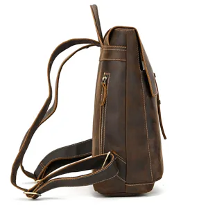 Side detail view of vintage brown leather backpack showing sturdy straps and zipper pocket.