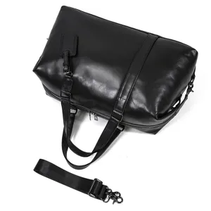 Black genuine leather duffel bag detail, large capacity travel luggage and gym sports bag.