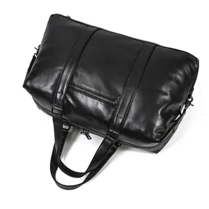 Detailed view of the black genuine leather travel duffel bag showing the zipper pocket.
