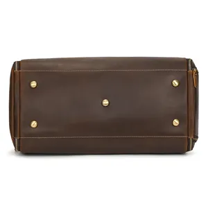 Genuine leather vintage travel duffel bag bottom detail, brown cowhide with metal base studs.