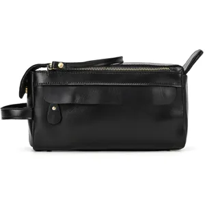 Black genuine leather toiletry bag detail, metal zipper, vintage travel clutch close-up.
