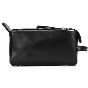 Close-up detail view of black genuine leather toiletry bag, premium travel zipper pouch.