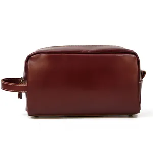 Leather toiletry bag detail showcasing premium brown leather, neat white stitching and side handle.
