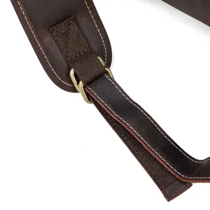 Close-up view of the vintage leather backpack strap showing detailed stitching and durable hardware.