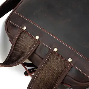 Detail view of genuine crazy horse leather backpack straps, showing reinforced metal rivets and mesh.