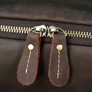 Detailed view of genuine crazy horse leather vintage backpack metal zipper and puller.